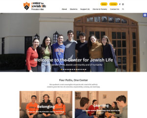 Group of seven smiling students standing arm-in-arm outside a campus building, forming a welcoming banner for the Center for Jewish Life at Princeton Hillel. | Addicott Web - Raleigh Web Designer & Website Design | Addicott Web - Raleigh Web Designer & Website Design